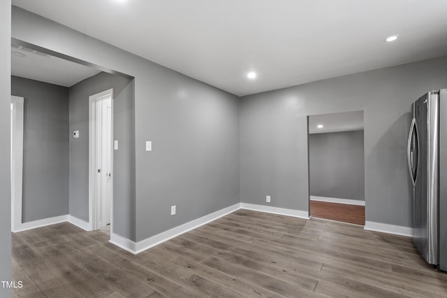 empty room featuring baseboards, wood finished floors, and recessed lighting