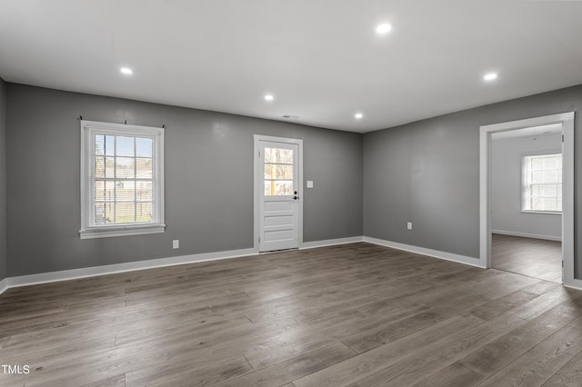 spare room featuring wood finished floors, a healthy amount of sunlight, and recessed lighting