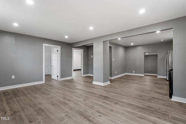 spare room with recessed lighting, baseboards, and wood finished floors
