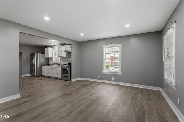kitchen featuring dark wood-style floors, white cabinetry, baseboards, and appliances with stainless steel finishes