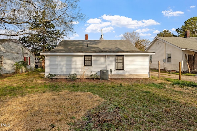 rear view of house featuring a lawn and central AC
