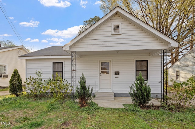 bungalow-style house with a front yard and entry steps
