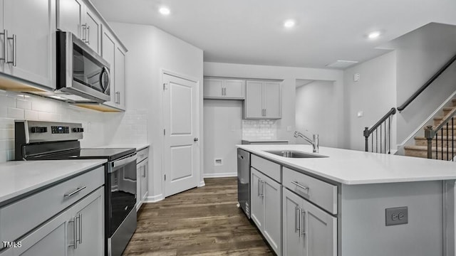 1010 Ocean Ct, Carthage, NC 28327 - kitchen featuring stainless steel appliances, dark wood finished floors, gray cabinets, light countertops, and tasteful backsplash