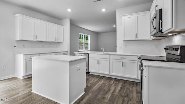 1014 Ocean Ct, Carthage, NC 28327 - kitchen with appliances with stainless steel finishes, dark wood-type flooring, white cabinets, a peninsula, and recessed lighting