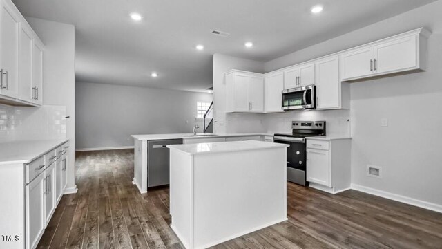 1014 Ocean Ct, Carthage, NC 28327 - kitchen featuring stainless steel appliances, a peninsula, dark wood-style floors, white cabinetry, and recessed lighting
