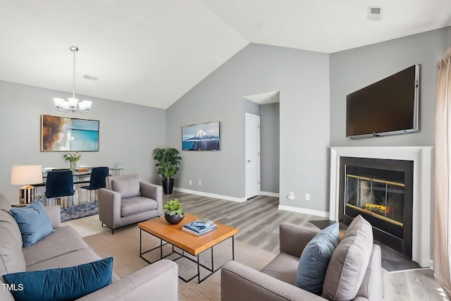 living area with visible vents, baseboards, an inviting chandelier, and light wood-style flooring