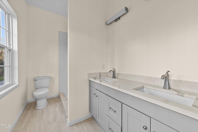 612 Lakeview Dr, Raleigh, NC 27603 - bathroom featuring toilet, healthy amount of natural light, double vanity, and baseboards