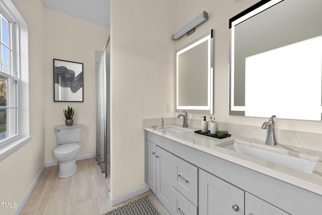 612 Lakeview Dr, Raleigh, NC 27603 - bathroom featuring toilet, double vanity, baseboards, and a shower with shower curtain