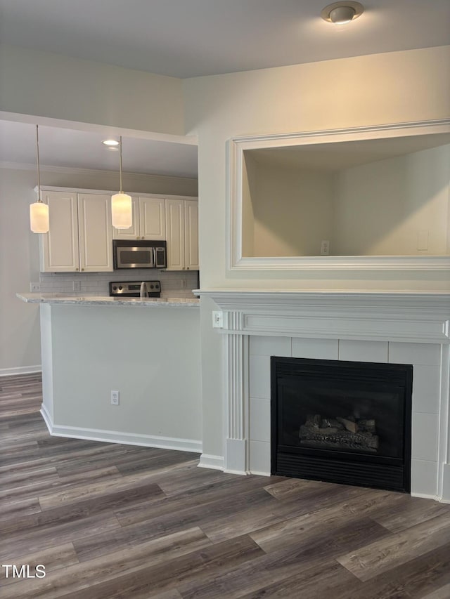 11035 Southwalk Ln, Raleigh, NC 27614 - kitchen with stainless steel microwave, electric range oven, dark wood finished floors, and hanging light fixtures