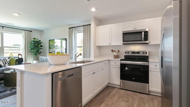 140 Holton St, Smithfield, NC 27577 - kitchen with a sink, white cabinetry, appliances with stainless steel finishes, a peninsula, and light countertops
