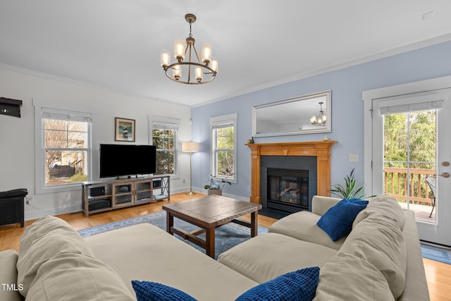 living room with baseboards, a chandelier, and wood finished floors