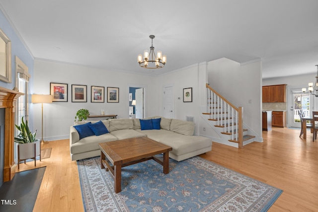living room with baseboards, light wood-type flooring, stairs, and a chandelier