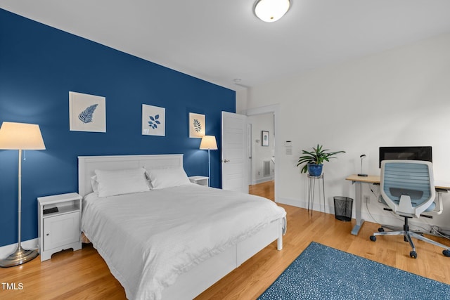 bedroom with visible vents, baseboards, and wood finished floors