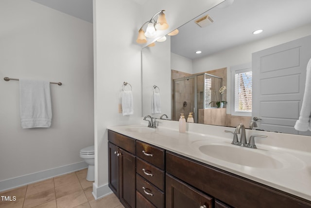 bathroom featuring double vanity, a sink, toilet, and a shower stall