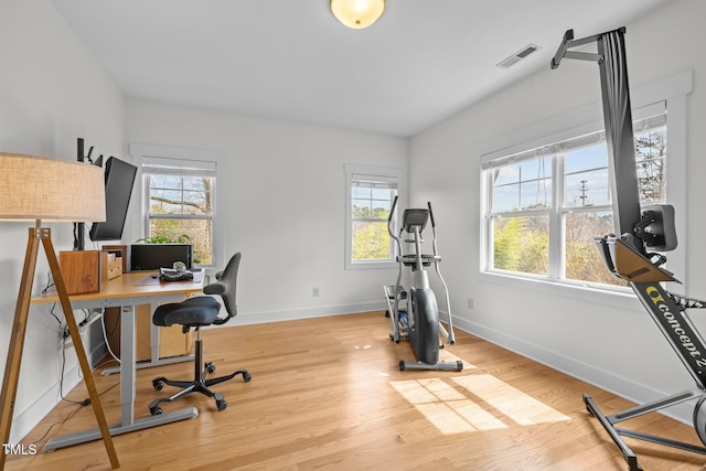 office area with visible vents, baseboards, wood finished floors, and a healthy amount of sunlight