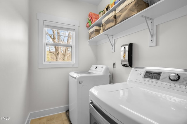 washroom featuring baseboards, laundry area, and washing machine and dryer