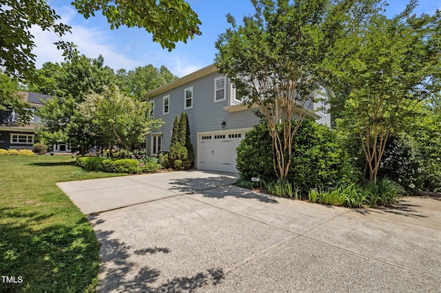 view of front of property featuring a garage, concrete driveway, and a front lawn