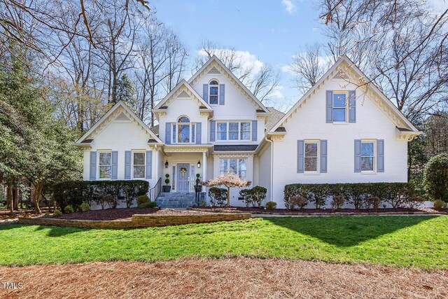 traditional-style home with brick siding and a front lawn