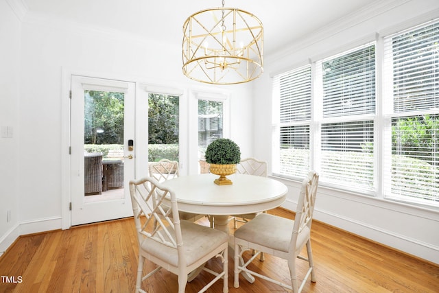 dining space featuring baseboards, a chandelier, crown molding, and light wood finished floors