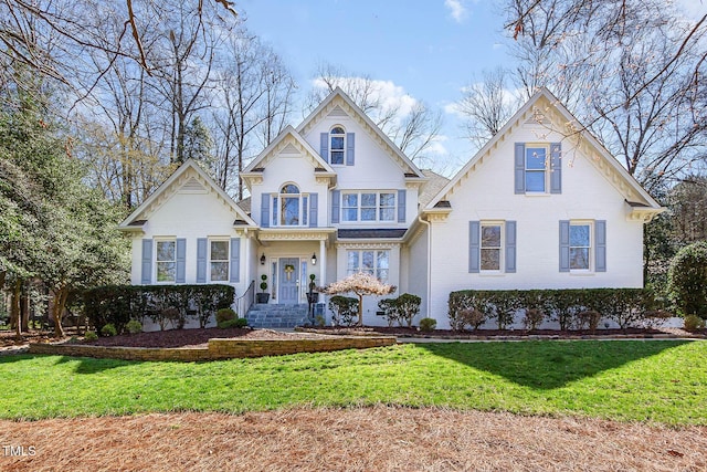 traditional-style home featuring a front lawn and brick siding
