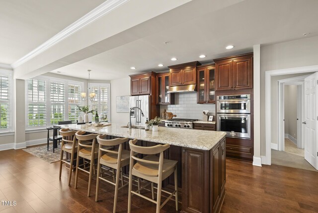 10529 Sablewood Dr Unit 111, Raleigh, NC 27617 - kitchen with under cabinet range hood, appliances with stainless steel finishes, a sink, crown molding, and backsplash