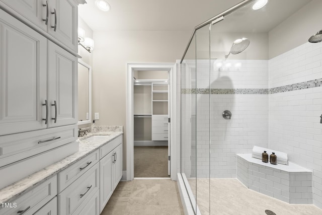 10529 Sablewood Dr Unit 111, Raleigh, NC 27617 - bathroom with a shower stall, vanity, a spacious closet, and recessed lighting