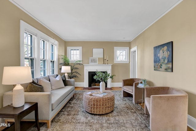living room with a fireplace with flush hearth, baseboards, wood finished floors, and crown molding