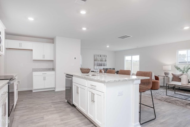 kitchen featuring a kitchen bar, a sink, plenty of natural light, and stainless steel appliances