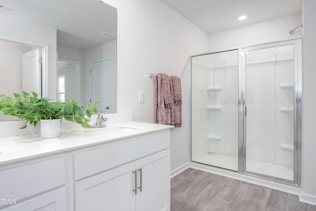 full bathroom with visible vents, recessed lighting, a shower stall, vanity, and wood finished floors