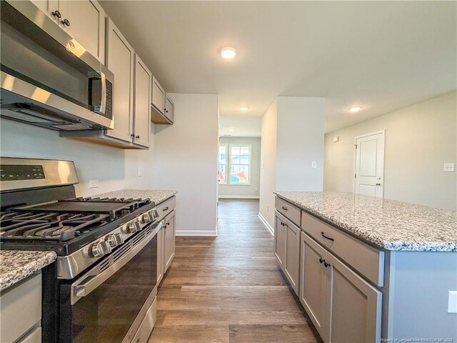 2224 Roadster Pony Rd, Hope Mills, NC 28348 - kitchen with stainless steel appliances, gray cabinets, wood finished floors, recessed lighting, and light stone counters