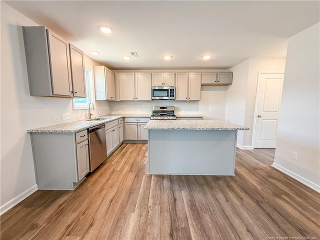 2224 Roadster Pony Rd, Hope Mills, NC 28348 - kitchen featuring appliances with stainless steel finishes, gray cabinets, light wood-style floors, and recessed lighting