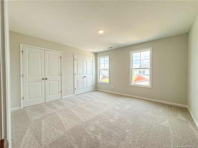 2224 Roadster Pony Rd, Hope Mills, NC 28348 - unfurnished bedroom featuring multiple closets and carpet flooring