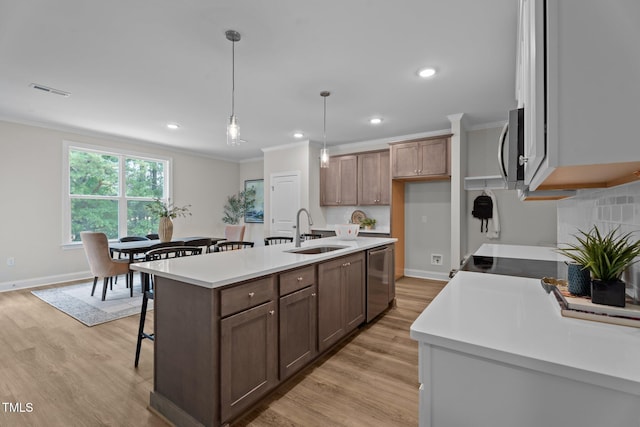 20 Diamond Creek Dr, Zebulon, NC 27597 - kitchen with stainless steel appliances, crown molding, light countertops, light wood-type flooring, and a kitchen breakfast bar