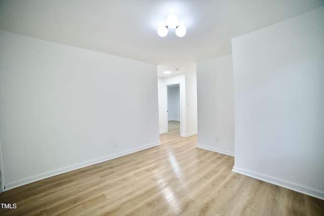 spare room featuring light wood-style flooring and baseboards