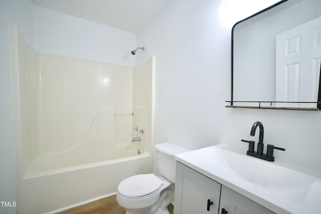 bathroom featuring toilet, vanity, bathing tub / shower combination, wood finished floors, and a textured ceiling