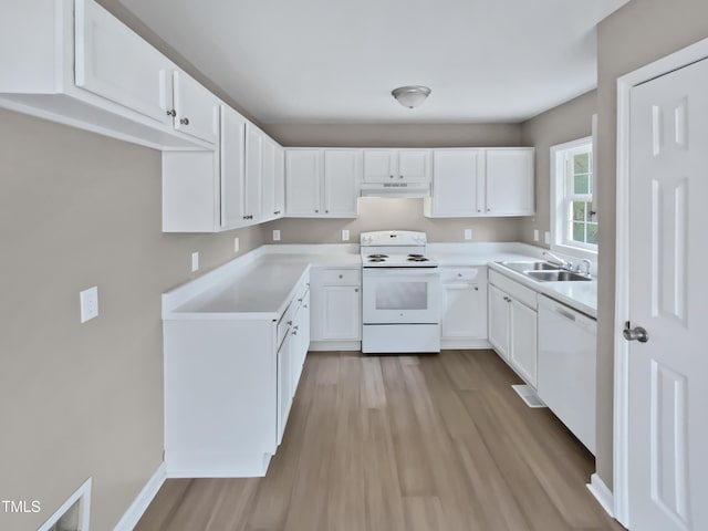 kitchen with light wood finished floors, under cabinet range hood, white cabinets, white appliances, and a sink