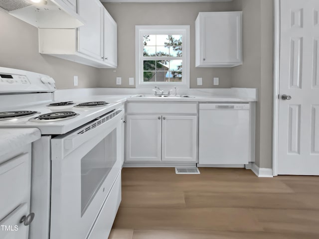 kitchen with under cabinet range hood, light countertops, white appliances, white cabinetry, and a sink