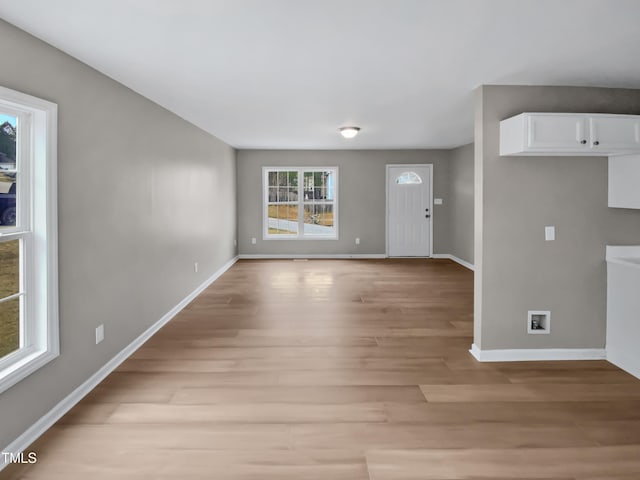 foyer with baseboards and light wood-style floors