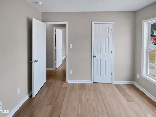 unfurnished bedroom with light wood finished floors and baseboards