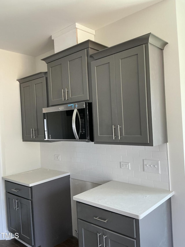 1039 N Lincoln St, Benson, NC 27504 - kitchen with stainless steel microwave, gray cabinets, and tasteful backsplash
