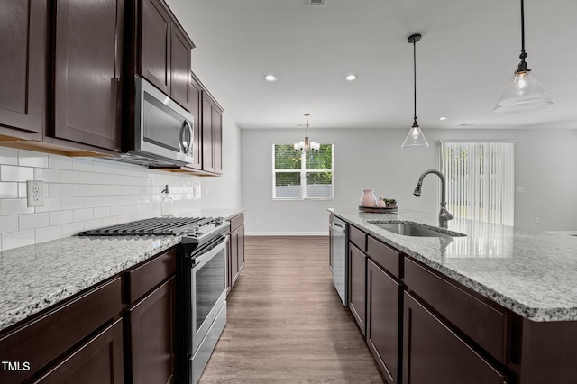 1028 Gallivant Way, Wake Forest, NC 27587 - kitchen featuring stainless steel appliances, a sink, dark wood-style flooring, tasteful backsplash, and dark brown cabinetry