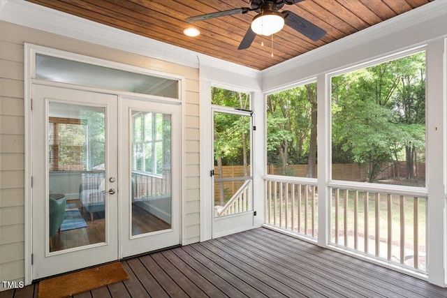 unfurnished sunroom featuring french doors, a ceiling fan, and a wealth of natural light
