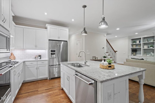 kitchen featuring crown molding, recessed lighting, white cabinetry, a sink, and appliances with stainless steel finishes
