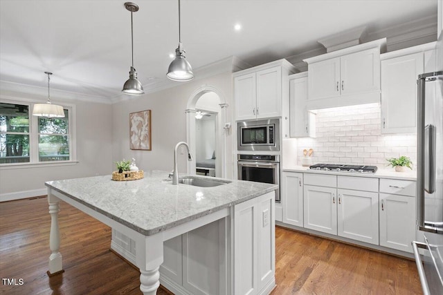 kitchen featuring backsplash, crown molding, a sink, white cabinets, and stainless steel appliances