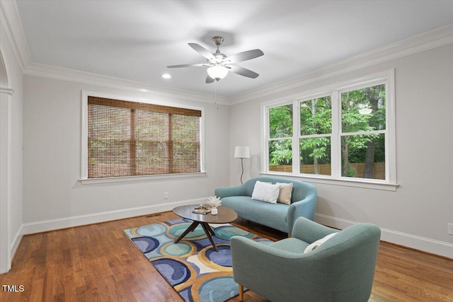 living room featuring baseboards, plenty of natural light, a ceiling fan, and wood finished floors