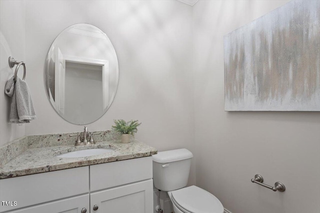 half bathroom featuring vanity and toilet