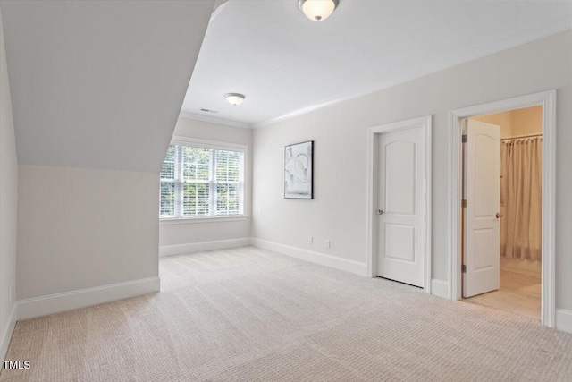 unfurnished bedroom with carpet floors, ornamental molding, baseboards, and connected bathroom