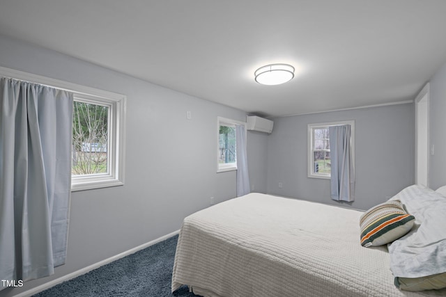 bedroom featuring baseboards, carpet flooring, and a wall mounted air conditioner