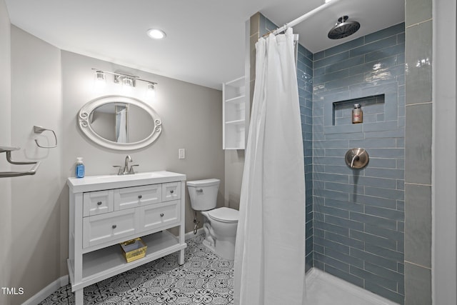 bathroom featuring vanity, baseboards, a tile shower, and toilet