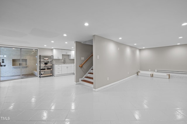 below grade area featuring recessed lighting, baseboards, a sink, and stairway